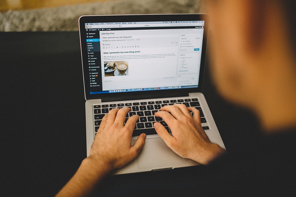 Man blogging with WordPress on Apple laptop computer